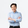 Business, finance and people concept. Professional confident asian businessman with teeth braces, smiling pleased, cross arms chest, standing white background, Salesman showing product.